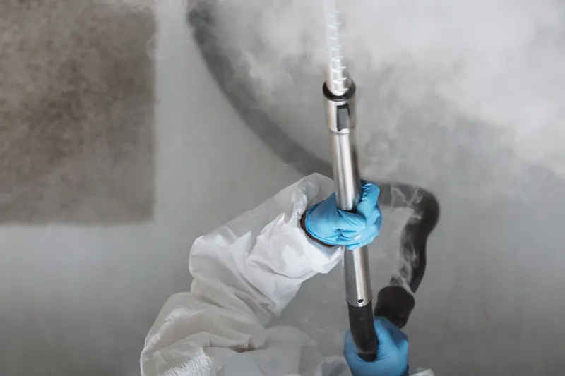 Overhead view of a protective suit worker fogging a room with disinfectant mist
